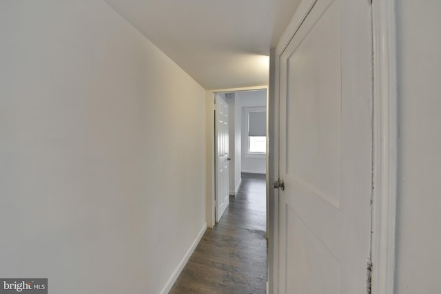 hall featuring baseboards and dark wood finished floors