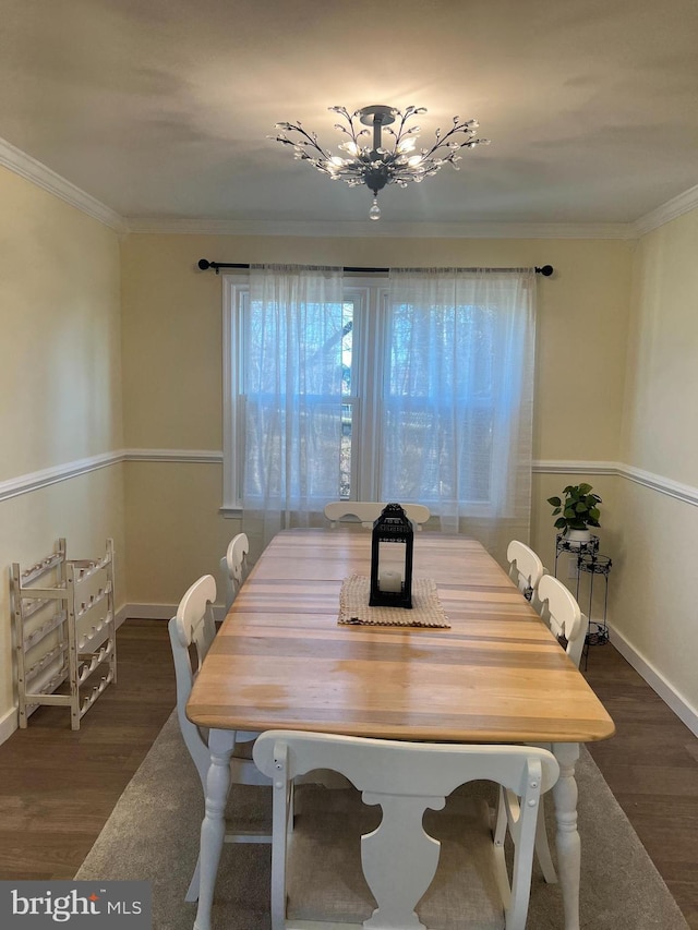 dining area with ornamental molding, dark wood-style flooring, baseboards, and an inviting chandelier