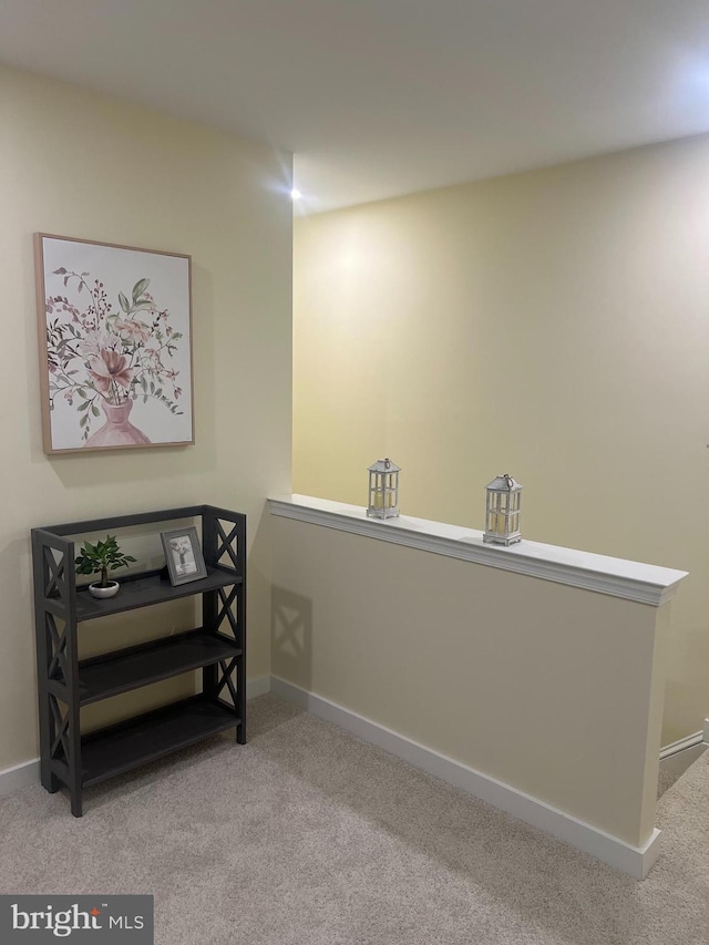 living area with baseboards, an upstairs landing, and light colored carpet