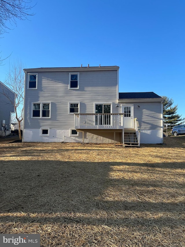 back of property with a lawn and a deck