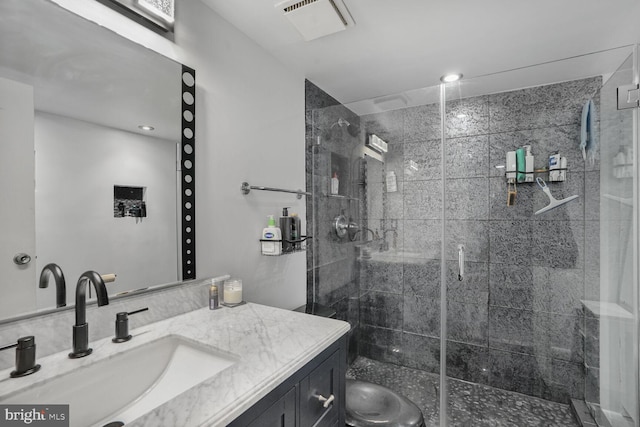 bathroom featuring toilet, a stall shower, vanity, and visible vents