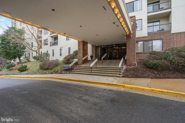 property entrance featuring visible vents and brick siding