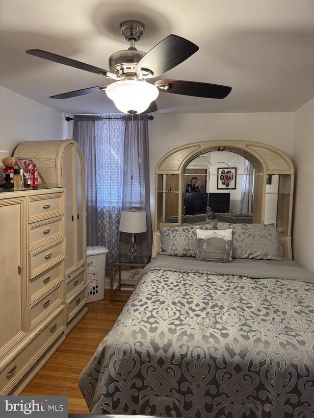 bedroom with light wood finished floors and a ceiling fan