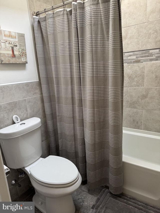 full bath featuring toilet, tile walls, and shower / bathtub combination with curtain