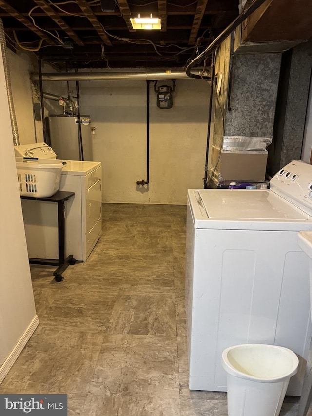 clothes washing area with gas water heater, independent washer and dryer, and laundry area