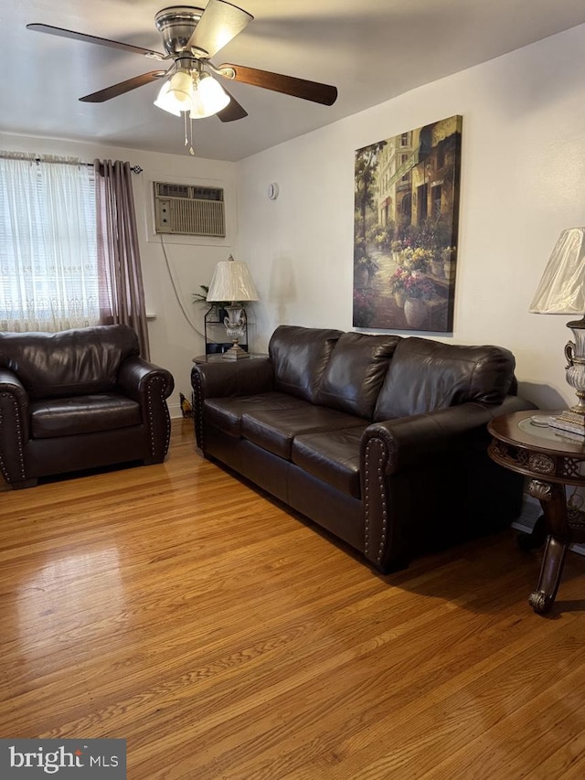 living room with light wood-style floors, ceiling fan, and a wall mounted AC