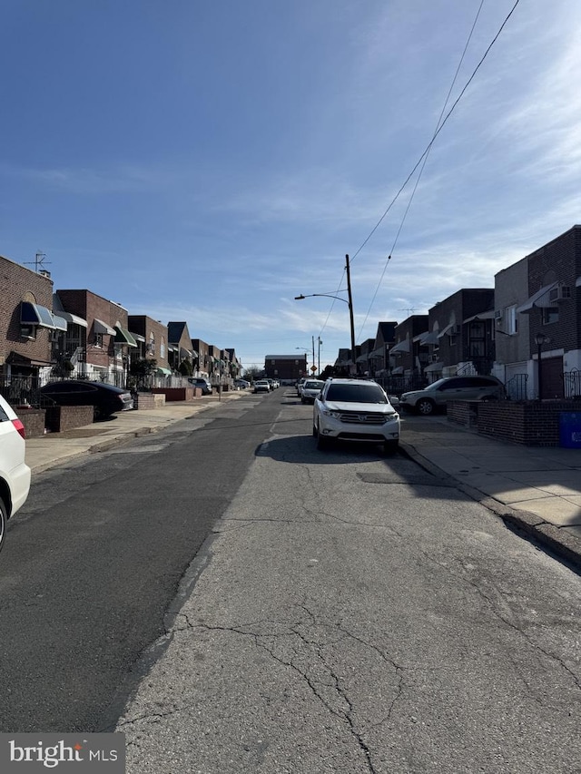 view of street with curbs, street lighting, sidewalks, and a residential view