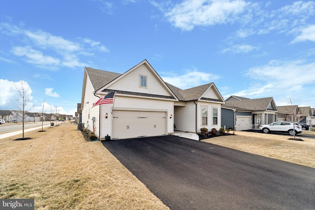 view of front facade with aphalt driveway, an attached garage, a shingled roof, a residential view, and a front yard