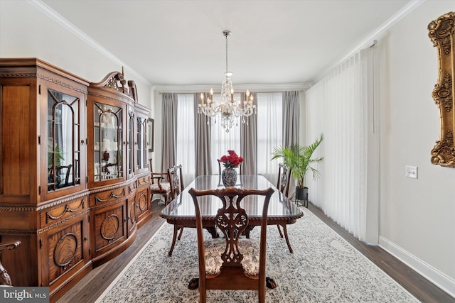 dining space featuring baseboards, ornamental molding, dark wood finished floors, and an inviting chandelier