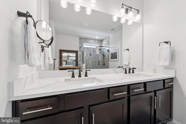 full bath featuring double vanity, a stall shower, and a sink