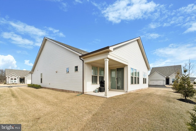 rear view of house featuring a patio area and a lawn