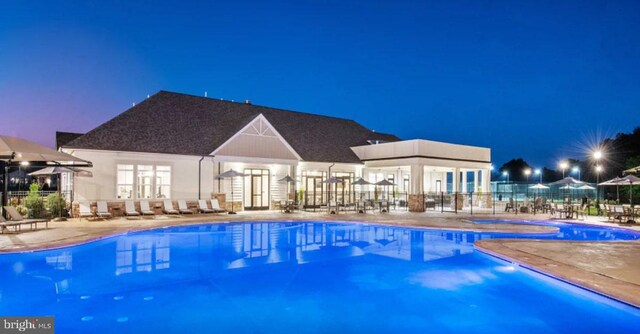 pool with a patio area and fence