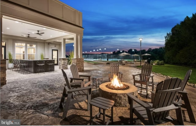 patio terrace at dusk with outdoor dry bar and an outdoor fire pit