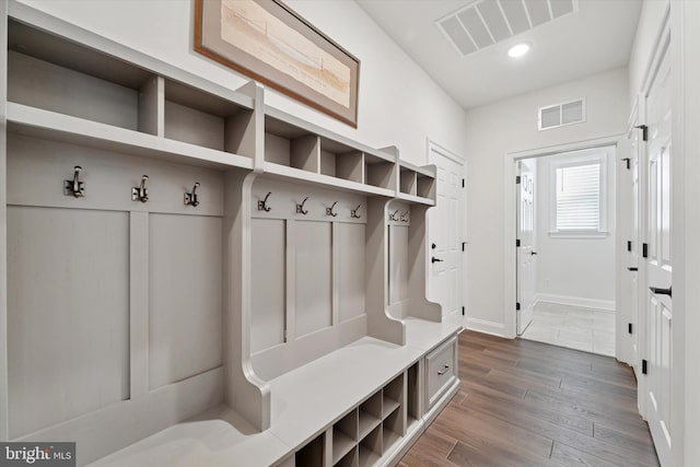 mudroom featuring dark wood-style flooring, visible vents, and baseboards