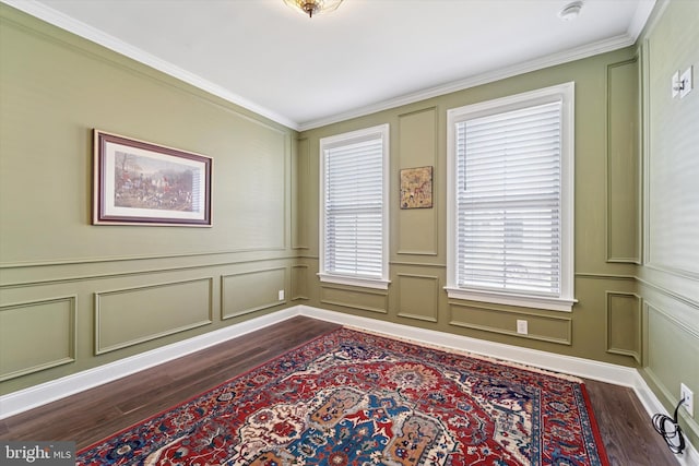 empty room featuring dark wood-style floors, plenty of natural light, and a decorative wall