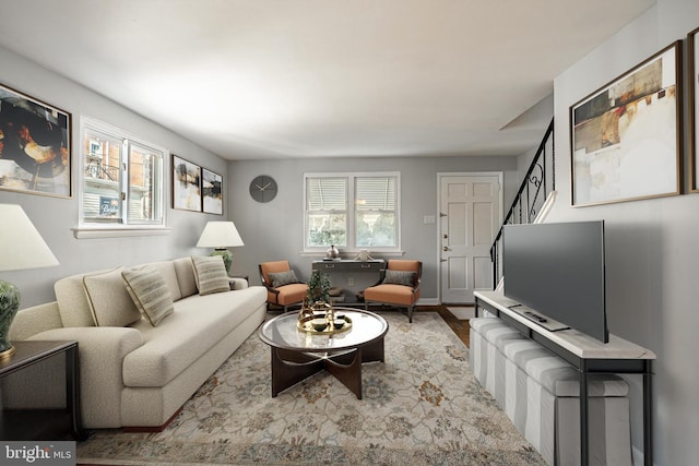 living area featuring stairs and baseboards