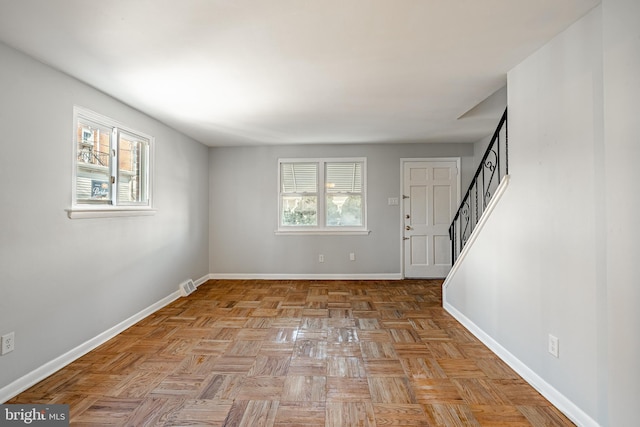 foyer entrance featuring a wealth of natural light, visible vents, baseboards, and stairway