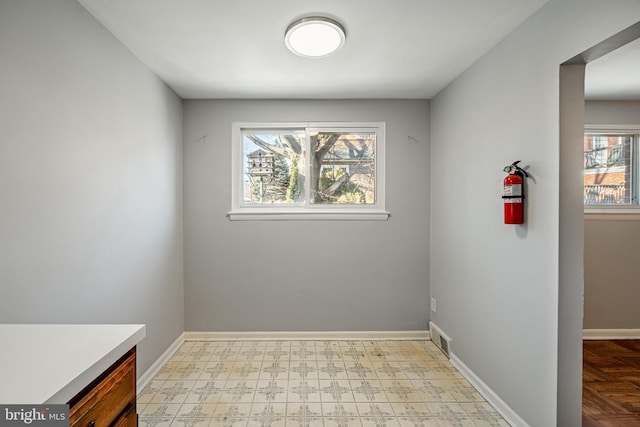 empty room with visible vents, light floors, and baseboards