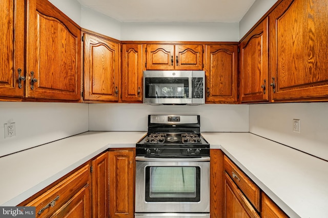 kitchen featuring light countertops, brown cabinets, and appliances with stainless steel finishes