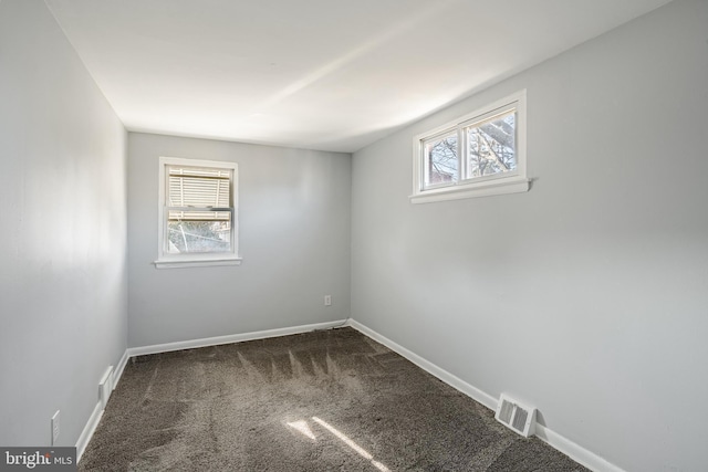 empty room featuring visible vents, carpet flooring, and baseboards