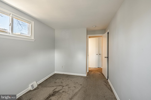 unfurnished bedroom with carpet flooring, baseboards, and visible vents