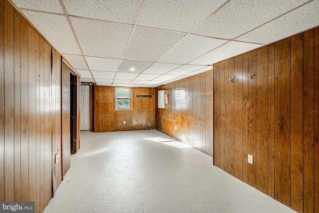 interior space with wood walls and a paneled ceiling