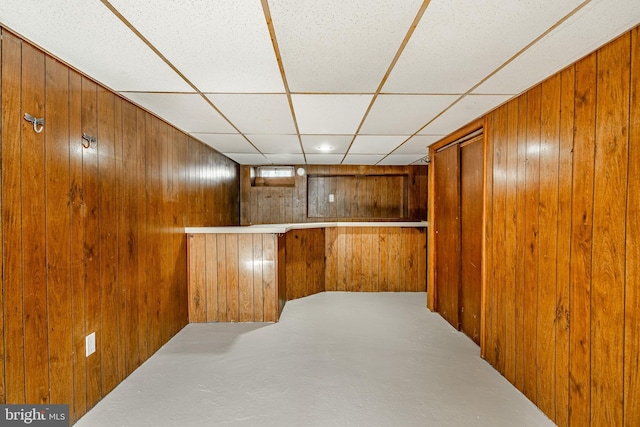 interior space with wooden walls and a paneled ceiling