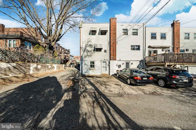 back of house featuring uncovered parking