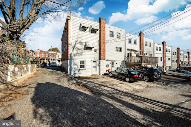 rear view of house featuring uncovered parking and a residential view