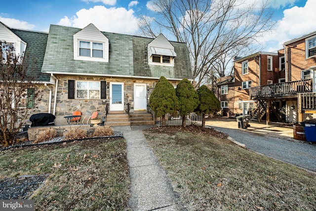 view of front of house with stone siding and a shingled roof