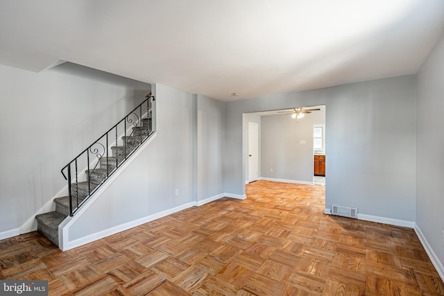 spare room with visible vents, baseboards, a ceiling fan, and stairs