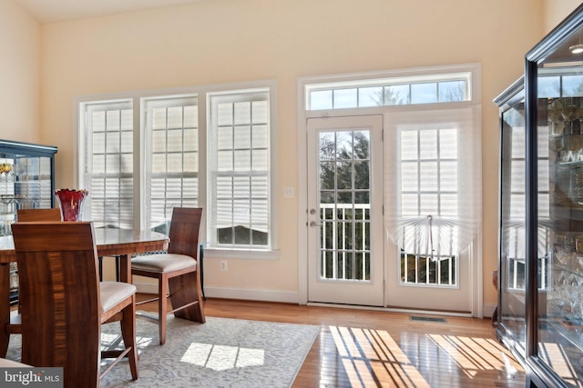 entryway with wood finished floors, visible vents, and baseboards