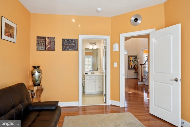 living room with stairs, baseboards, and wood finished floors