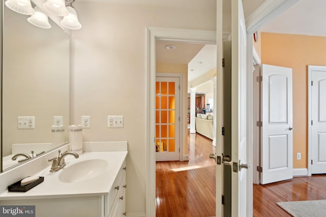 bathroom featuring wood-type flooring, baseboards, and vanity