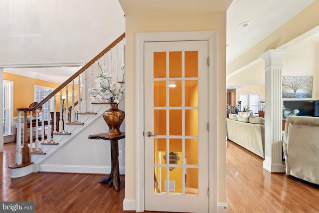 interior space with wood finished floors, visible vents, baseboards, stairs, and ornate columns