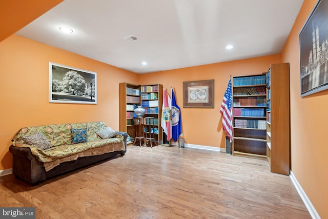 living area with recessed lighting, baseboards, and wood finished floors