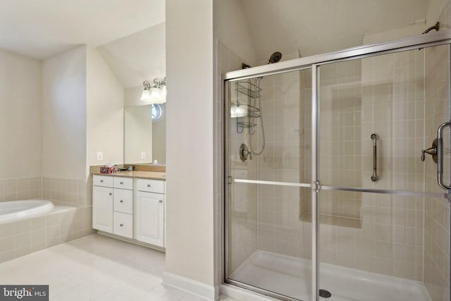 bathroom with a stall shower, a garden tub, vanity, and tile patterned floors