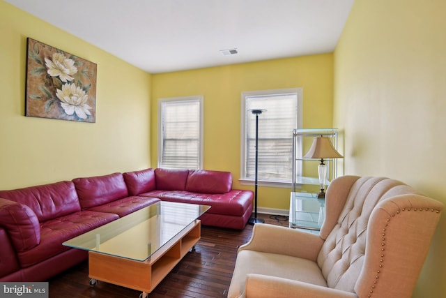 living room with dark wood-type flooring, visible vents, and baseboards