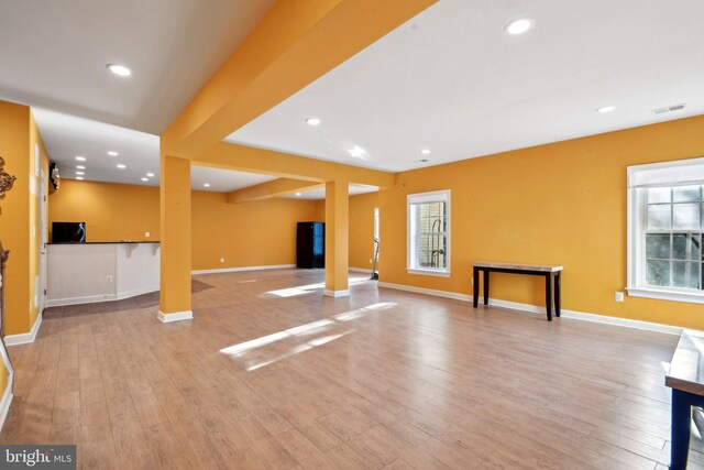 unfurnished living room with recessed lighting, plenty of natural light, and wood finished floors