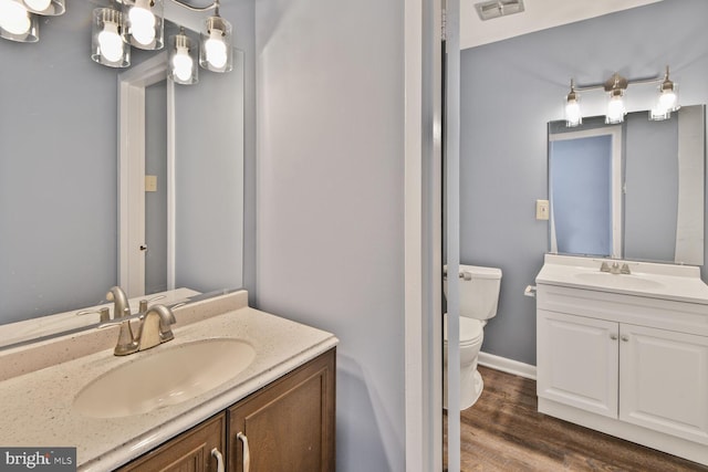 bathroom featuring wood finished floors, visible vents, toilet, and a sink