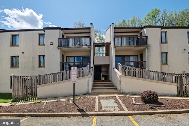 exterior space featuring uncovered parking and fence