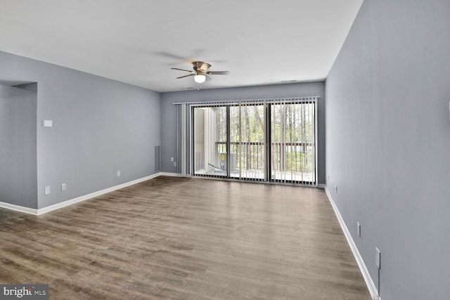 unfurnished room with wood finished floors, baseboards, and ceiling fan