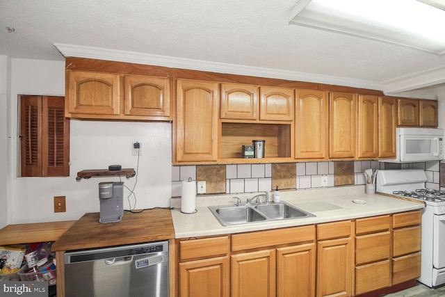 kitchen with a textured ceiling, white appliances, a sink, light countertops, and decorative backsplash