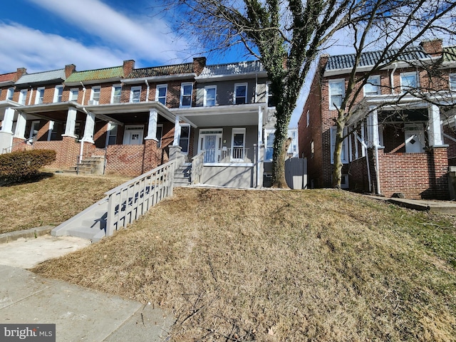 multi unit property featuring brick siding and a front yard