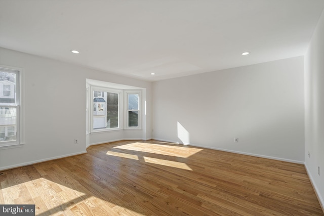 unfurnished room featuring recessed lighting, baseboards, and wood finished floors