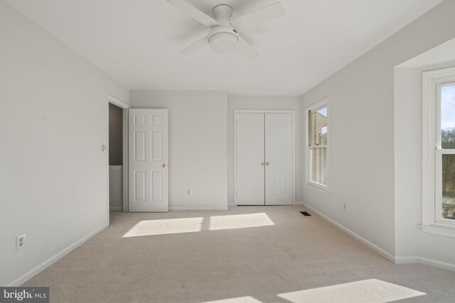 unfurnished bedroom featuring a closet, carpet flooring, baseboards, and visible vents