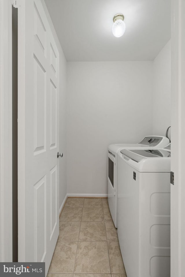 washroom featuring laundry area, light tile patterned floors, baseboards, and independent washer and dryer