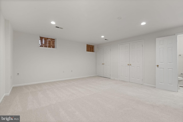 finished basement featuring light carpet, visible vents, recessed lighting, and baseboards