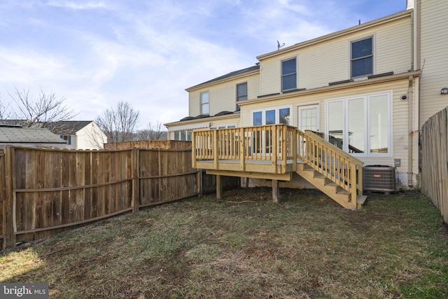 back of property with fence, a lawn, central AC, and a wooden deck