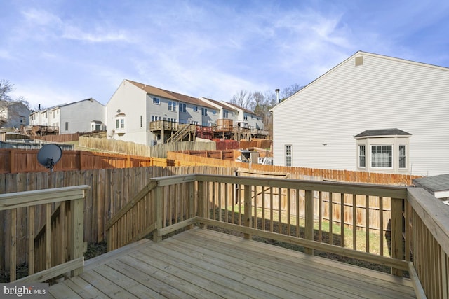 wooden terrace featuring a residential view and a fenced backyard